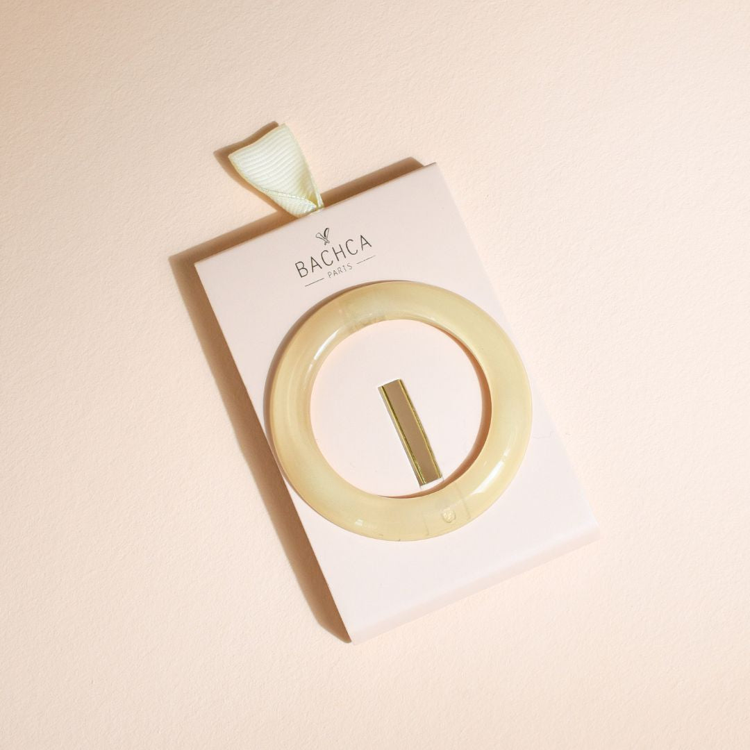 Barrette ronde ivoire Bachca présentée sur son packaging, accessoire chic et minimaliste pour sublimer toutes vos coiffures.