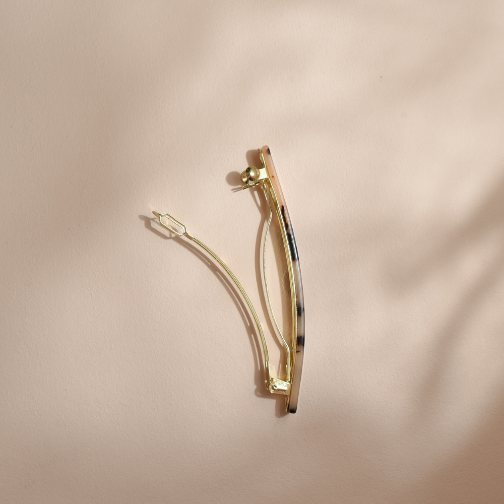 Barrette rectangle Bachca vue de côté, structure dorée élégante et motif écaille discret pour un maintien chic des cheveux.