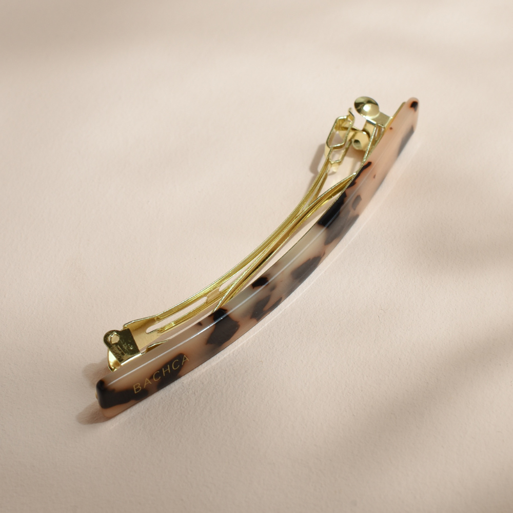 Barrette rectangle Bachca en acétate motif écaille, monture dorée élégante pour attacher les cheveux avec style.