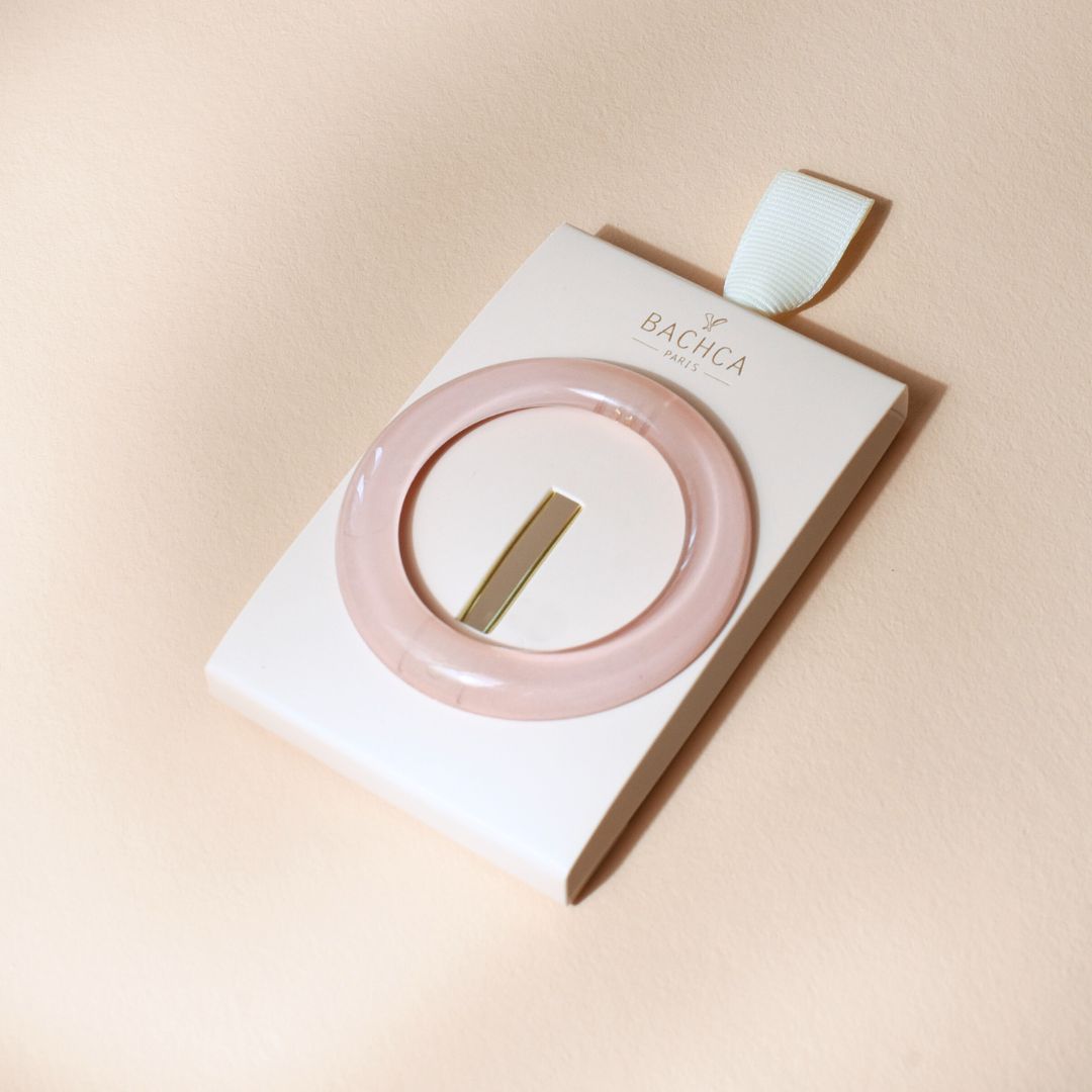 Barrette ronde rose dragée Bachca sur son emballage, accessoire raffiné pour cheveux, parfait pour un style féminin et délicat.