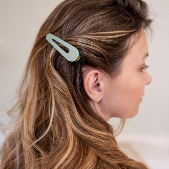 Barrette vert d’eau Bachca positionnée sur le côté, accessoire raffiné pour maintenir les mèches avec style.