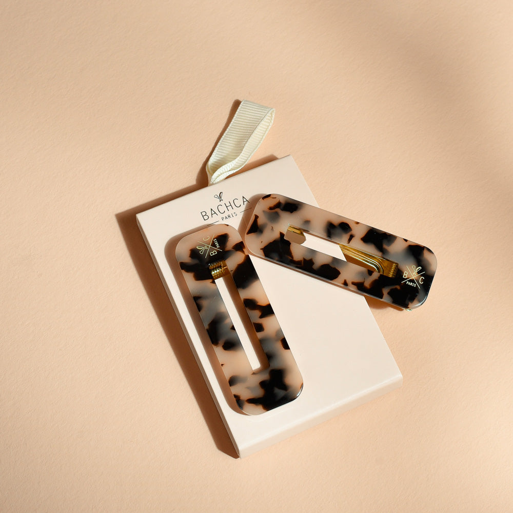 Deux barrettes Bachca rectangulaires effet écaille, en acétate de cellulose, fixées sur leur emballage, parfaites pour maintenir les cheveux avec élégance.