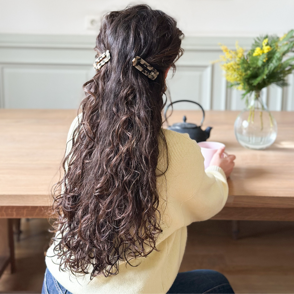 Femme de dos aux cheveux longs bouclés attachés à l&