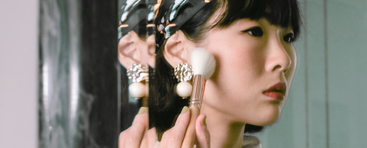 Femme se maquillant à l'aide d'un pinceau blush de la marque Bachca.