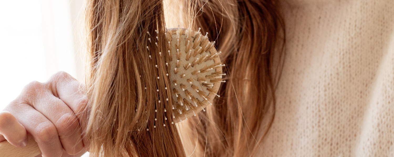 Zoom sur une brosse Bachca qui démêle des cheveux châtain.