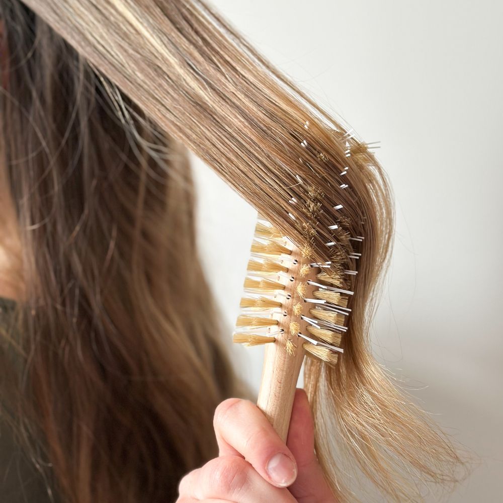 Brossage des cheveux avec la brosse ronde Bachca en bois pour un brushing naturel et doux.