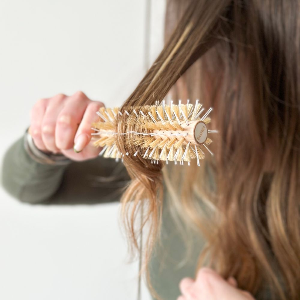 Brushing avec la brosse ronde Bachca en bois naturel, picots mixtes, pour lisser et coiffer.
