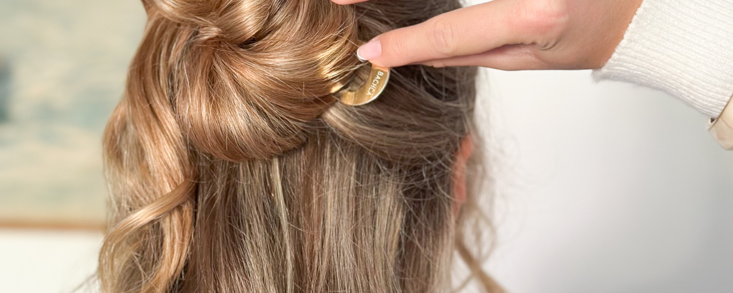 Zoom sur des cheveux blonds longs attachés en demi-chignon avec un pic chignon Bachca.