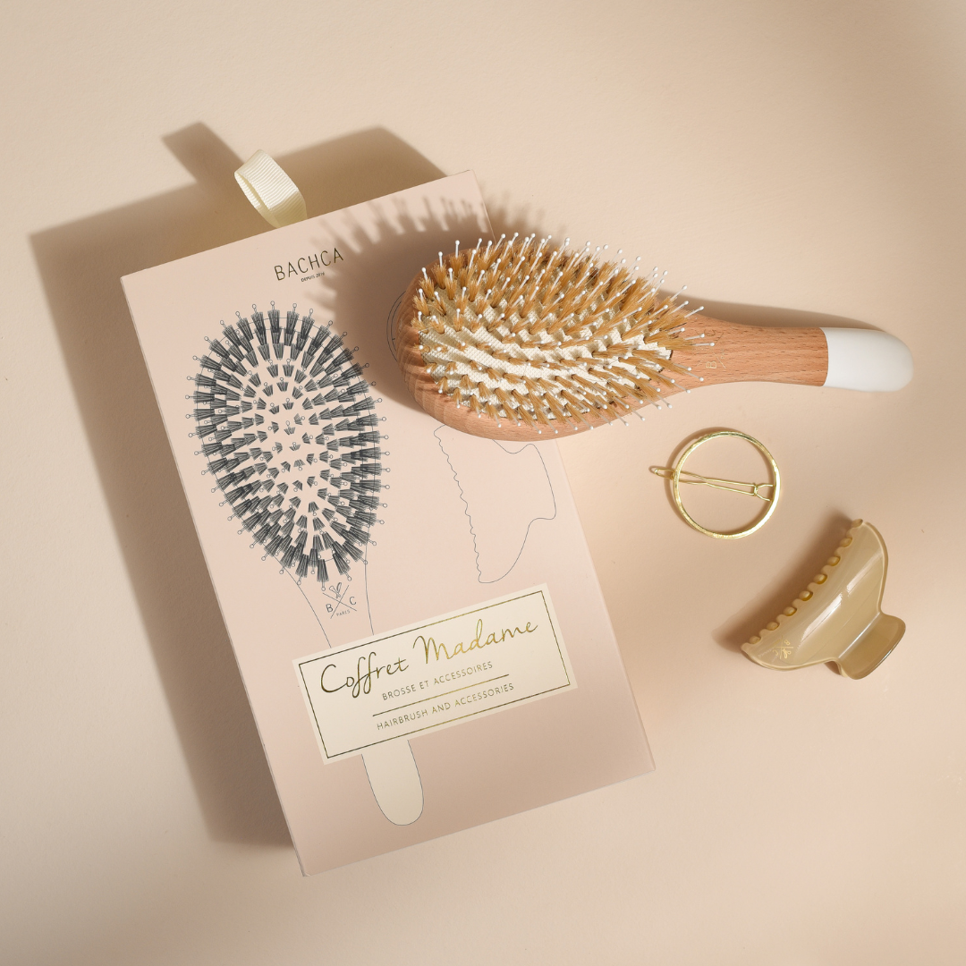 Coffret Madame Bachca avec brosse en bois à picots nylon et sanglier, barrette ronde dorée et pince crème, présenté sur un fond beige.