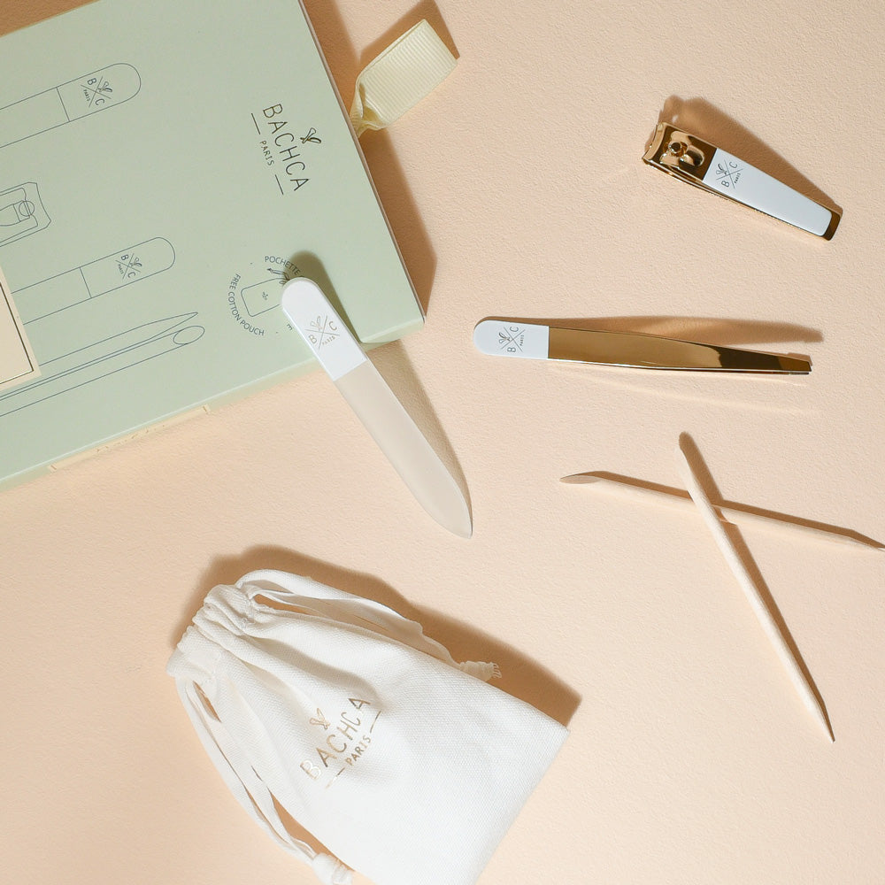 Kit manucure Bachca avec lime à ongles, pince à épiler, coupe-ongles, bâtonnets de buis et pochette en coton rangés dans un élégant coffret vert pastel.