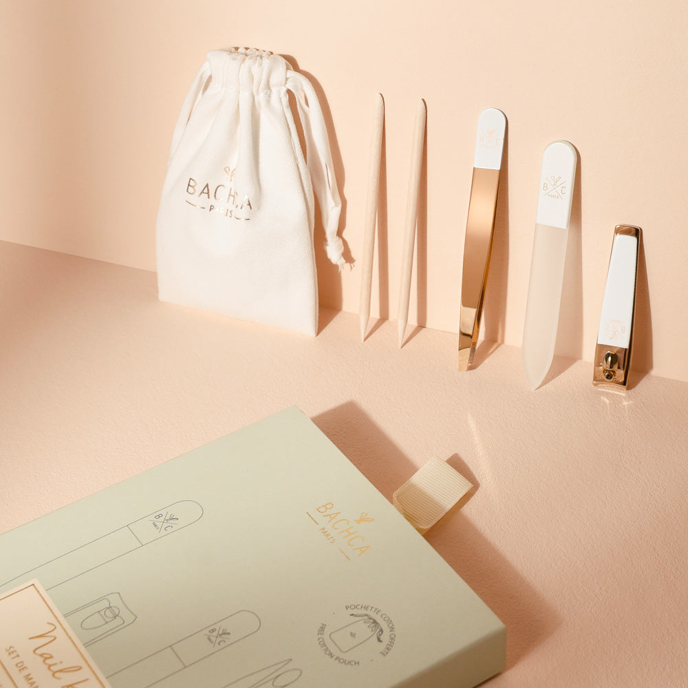 Coffret manucure Bachca comprenant une lime à ongles, une pince à épiler, un coupe-ongles, deux bâtonnets et une pochette en coton, présenté sur une surface beige.