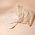 Lot de cotons démaquillants lavables Bachca en tissu beige, présentés avec leur filet de lavage assorti, photographiés sur une surface beige.