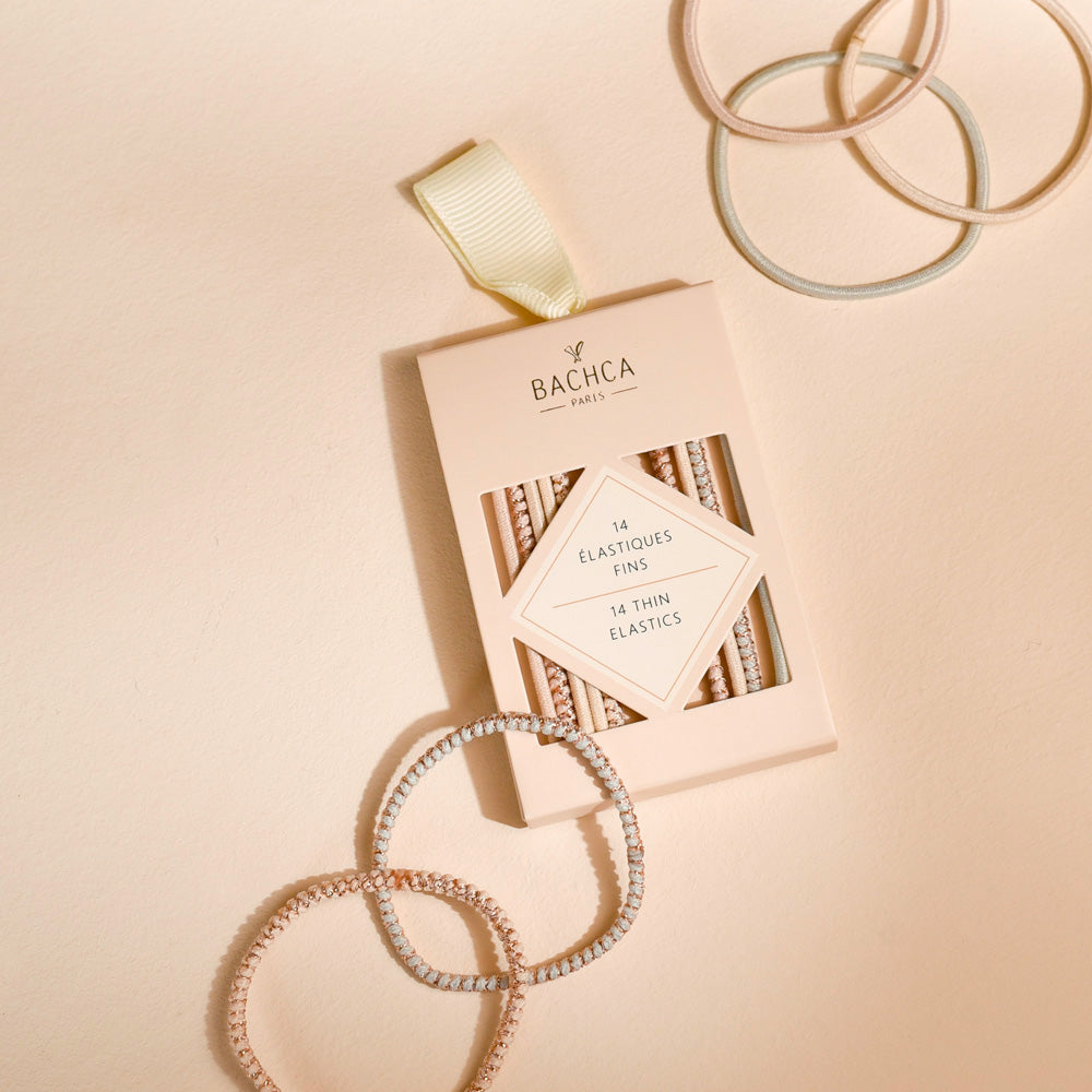 Lot de 14 élastiques cheveux fins Bachca en tons nude et pastel, discrets et résistants, parfaits pour des coiffures élégantes et naturelles.