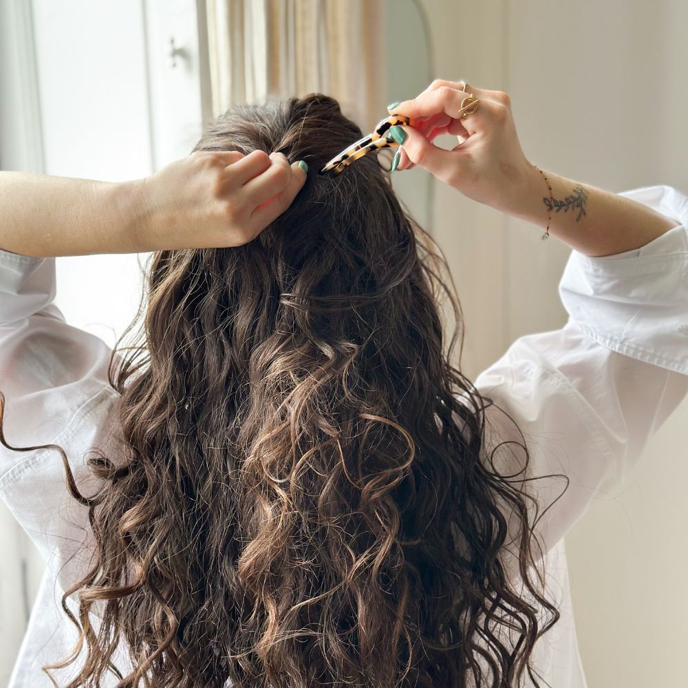 Attache de cheveux bouclés avec une épingle à chignon écaille signée Bachca, vue de dos.