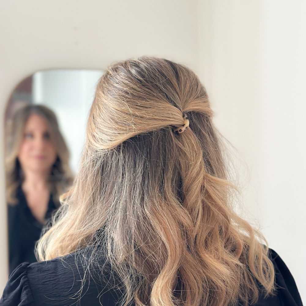 Cheveux blonds ondulés attachés avec une épingle à chignon écaille en demi-queue signée Bachca.
