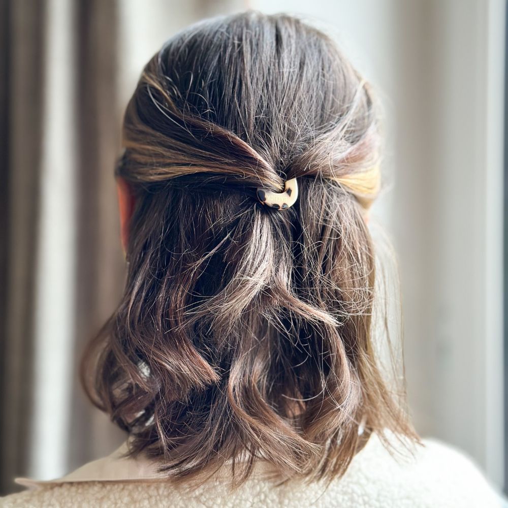 Cheveux mi-longs attachés en demi-queue avec une épingle à chignon écaille signée Bachca.