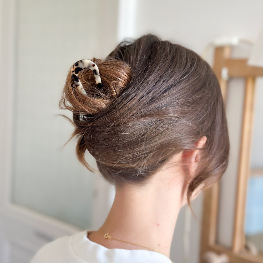 Chignon élégant réalisé avec le grand pic chignon écaille Bachca, accessoire raffiné en acétate de cellulose qui maintient parfaitement les cheveux tout en apportant une touche sophistiquée.