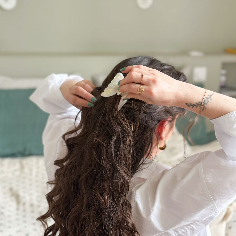 Cheveux longs bouclés attachés avec grande pince nacrée Bachca, élégance naturelle au quotidien.