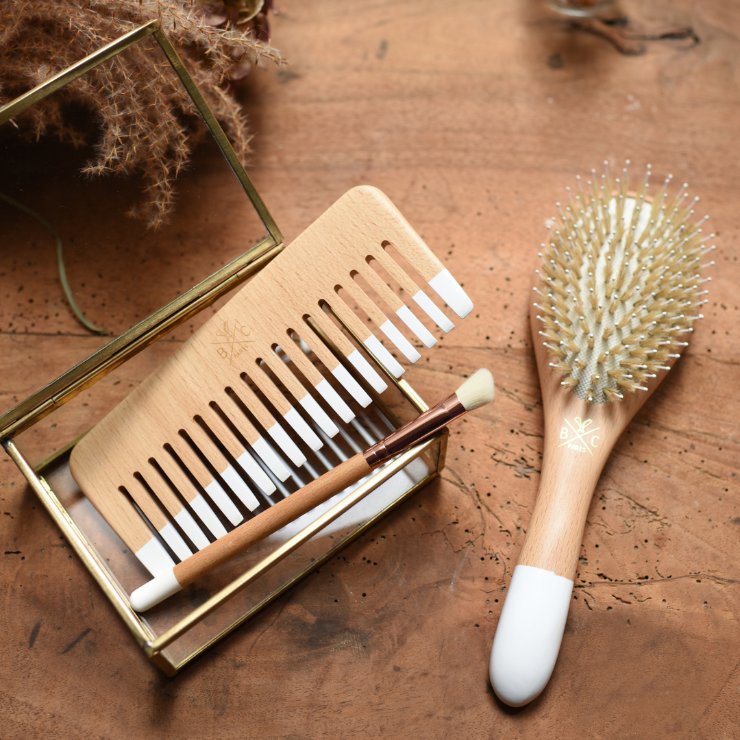 Peigne en bois, brosse à cheveux et pinceau maquillage Bachca sur fond bois, présentés dans une mise en scène naturelle et chaleureuse.