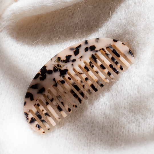 Peigne demi-lune écaille Bachca en acétate de cellulose, accessoire cheveux élégant posé sur un fond en maille.