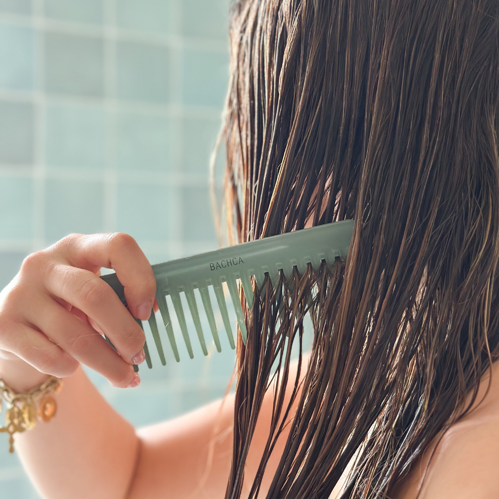 Femme utilisant dans ses cheveux mouillés un peigne vert d'eau de la marque Bachca.
