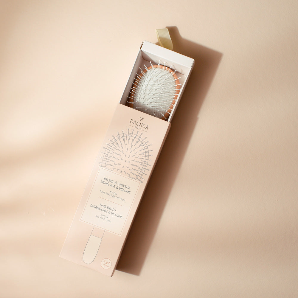Petite brosse Bachca en bois clair et blanc, picots nylon, présentée dans son coffret beige rosé.