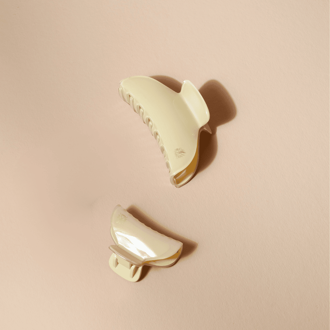 Deux pinces à cheveux Bachca en acétate effet ivoire, l’une grande et l’autre petite, posées à plat sur un fond beige doux.