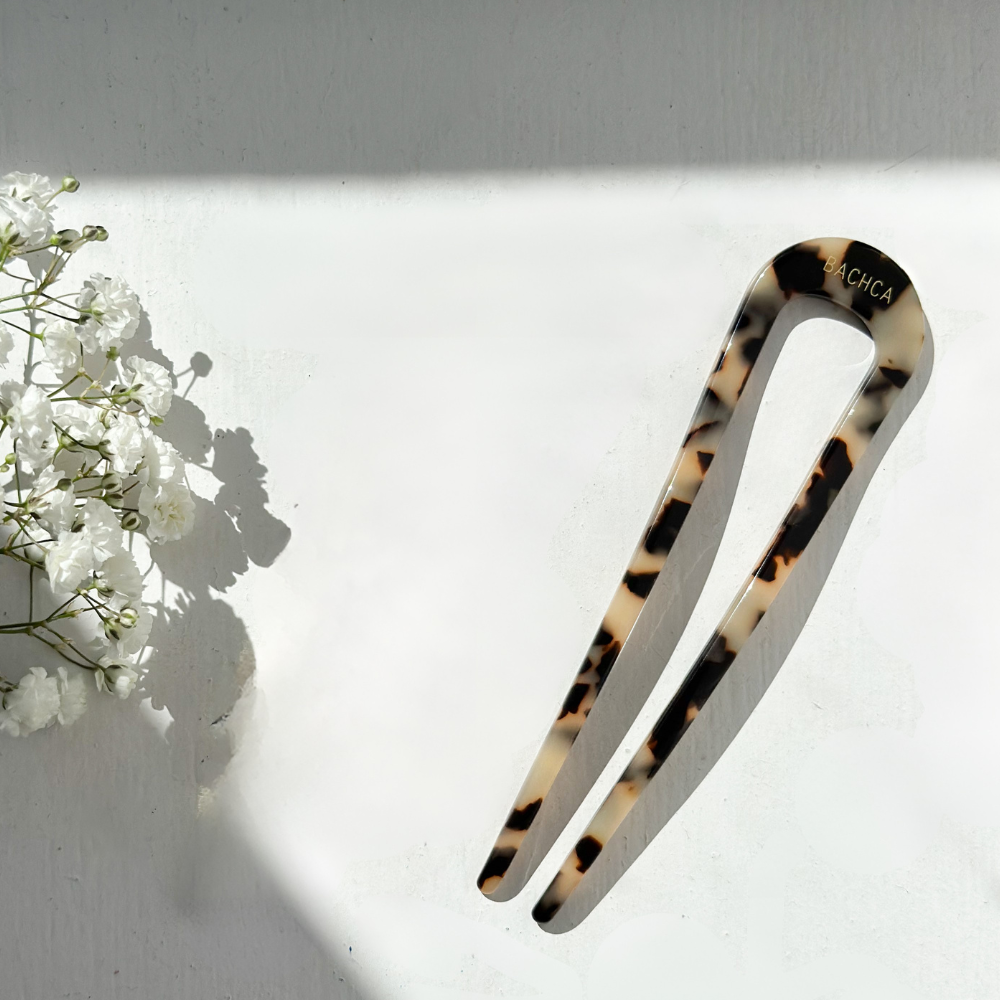 Pic chignon écaille Bachca posé sur une surface lumineuse, accessoire élégant.