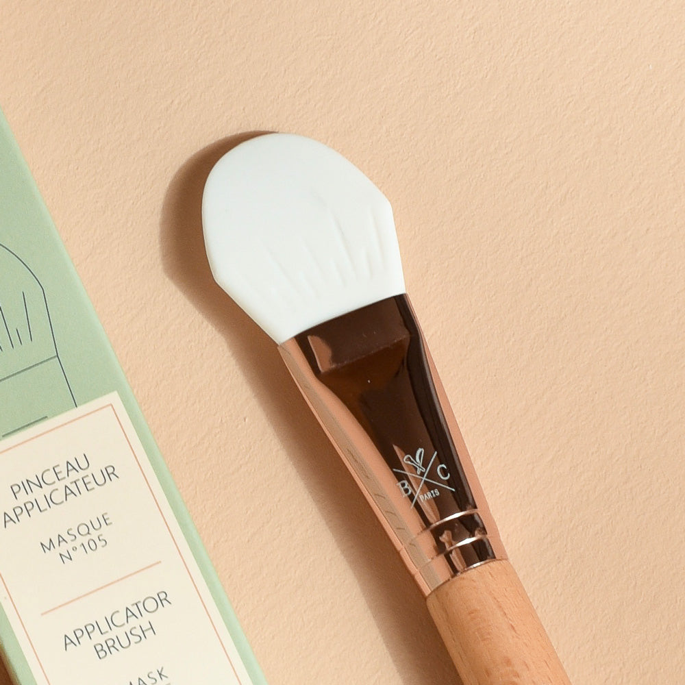 Pinceau applicateur de masque Bachca avec embout en silicone blanc, manche en bois de hêtre et bague rose gold pour une application uniforme des soins visage.