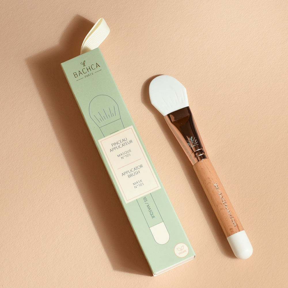 Pinceau applicateur de masque Bachca avec manche en bois de hêtre et embout en silicone blanc, présenté avec son étui vert élégant pour une application précise des soins visage.