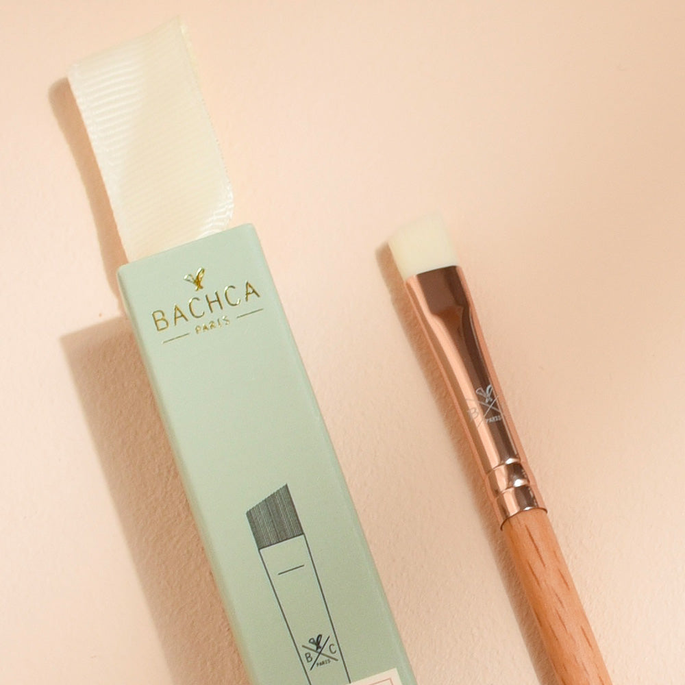 Pinceau sourcils et eye-liner Bachca avec manche en bois de hêtre et embout biseauté, accompagné de son étui vert pastel élégant.