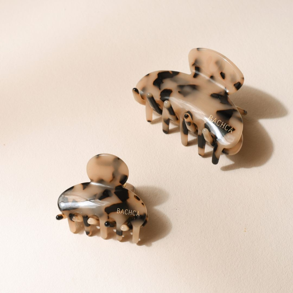 Duo de pinces à cheveux motif écaille de la marque Bachca, petite et moyenne taille, présentées sur fond rose pâle.