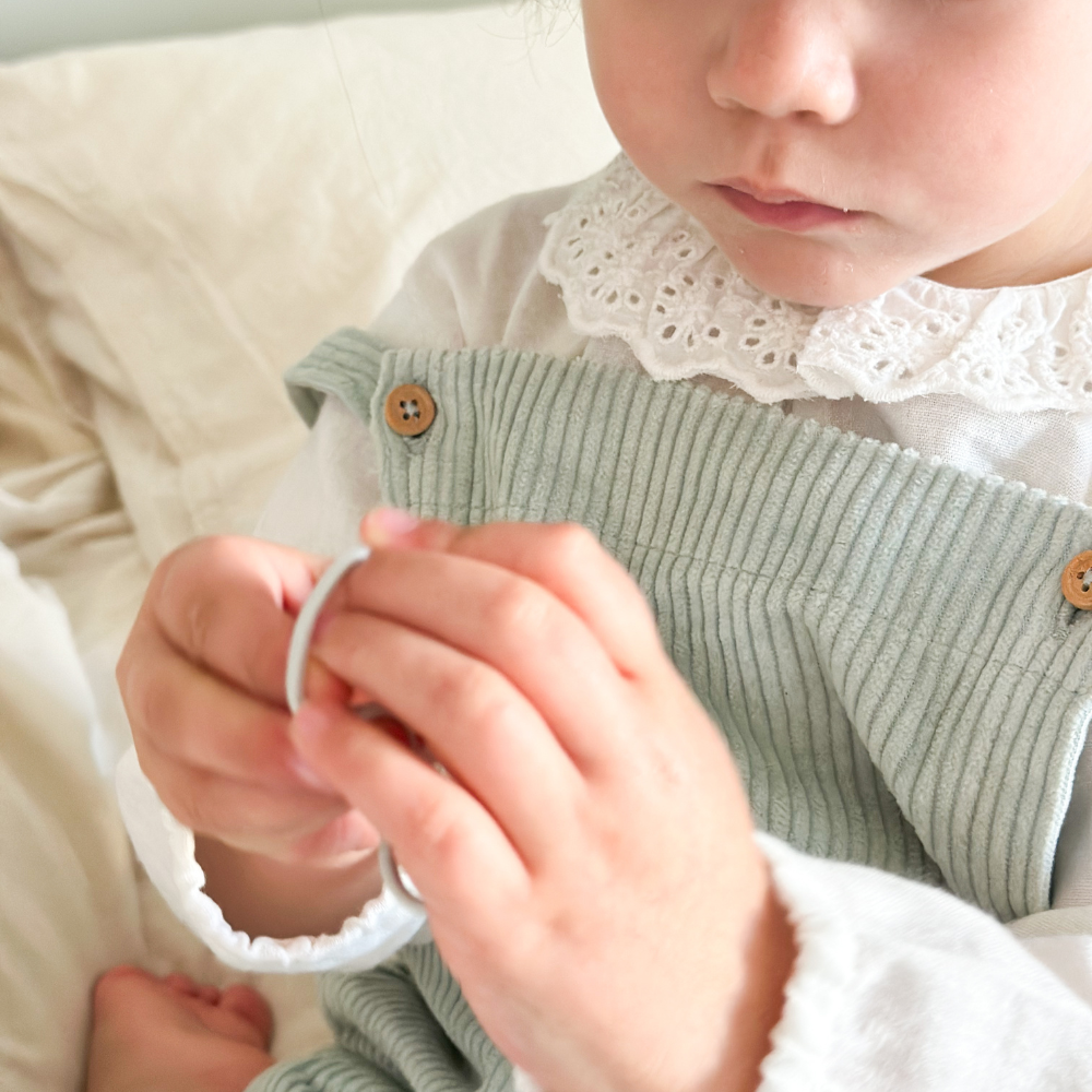 Zoom sur un élastique à cheveux fins de la marque Bachca dans les mains d&