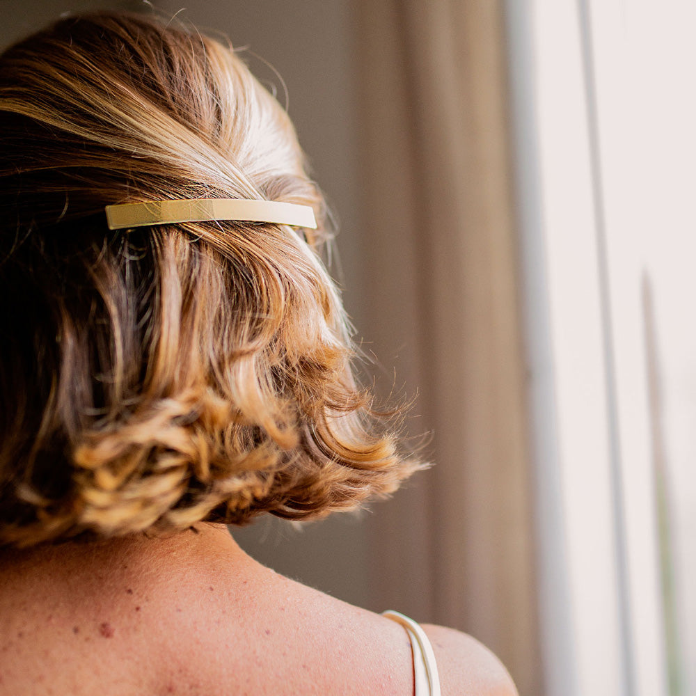 Barrette dorée Bachca, bijou de cheveux élégant pour attacher une demi-queue sur cheveux mi-longs ondulés, accessoire coiffure chic et tendance.