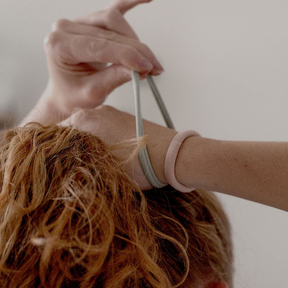 Élastiques cheveux pastels Bachca, portés au poignet et utilisés pour attacher une chevelure rousse, accessoires sobres et résistants au quotidien.
