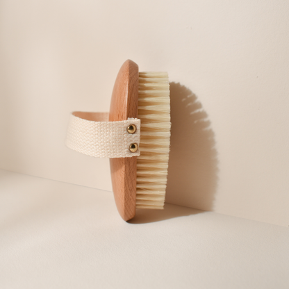 Photo studio sur fond beige, le produit mis en avant est la brosse de massage à sec Bachca, la brosse est en bois de hêtre, les poils sont en soie de sanglier.