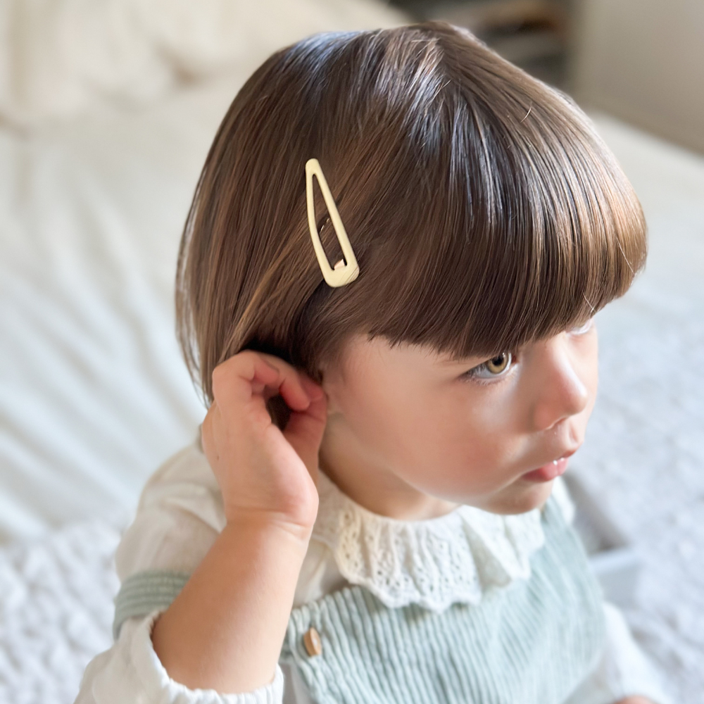Petite fille avec une barrette clic-clac de la marque Bachca dans les cheveux.