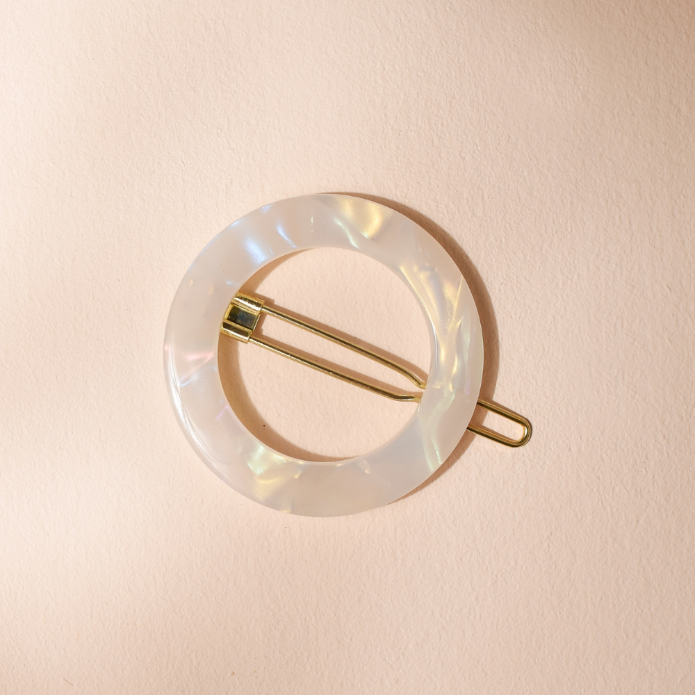Barrette ronde Bachca en acétate nacré avec fermoir doré, accessoire élégant et durable.