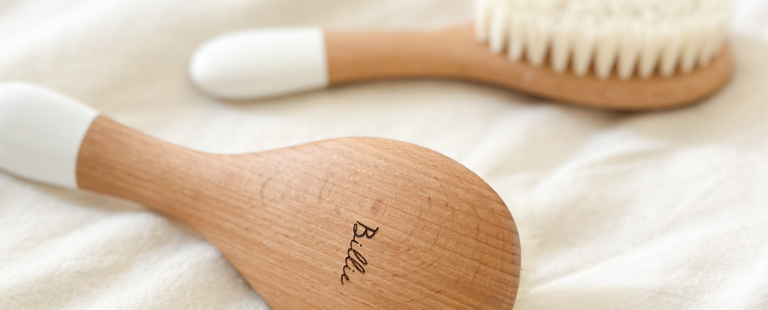 Gros plan sur deux brosses à cheveux naissance en soie de chèvre gravée "Billie" de la marque bachca. 