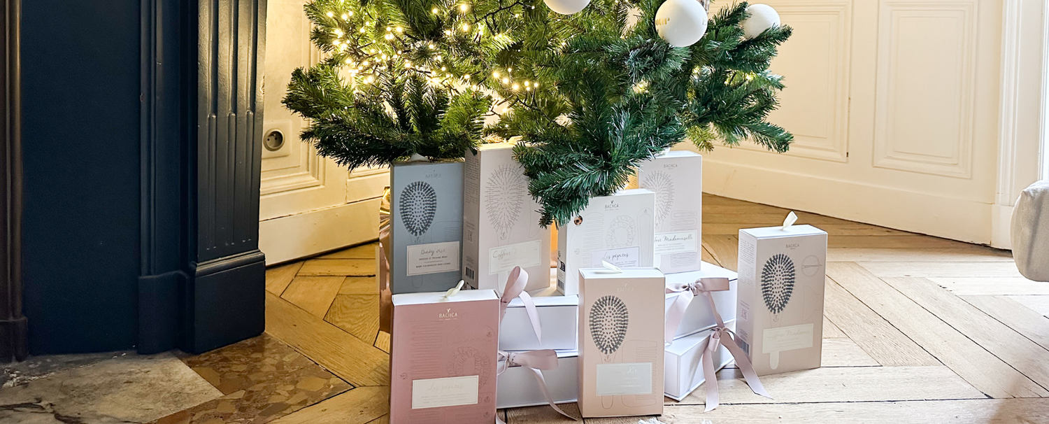 Coffrets d'accessoires cheveux de la marque Bachca disposés sous un sapin de noël. 
