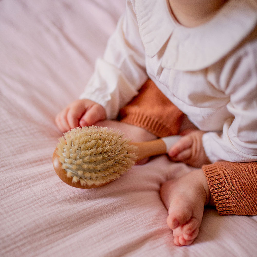 La brosseBachca cheveux fins et fragiles utilisée par un bébé.