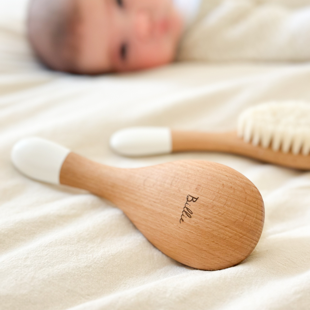 Deux brosses à cheveux pour nourrisson de la marque Bachca en premier plan, la première brosse est gravée avec le prénom Billie. Il y&