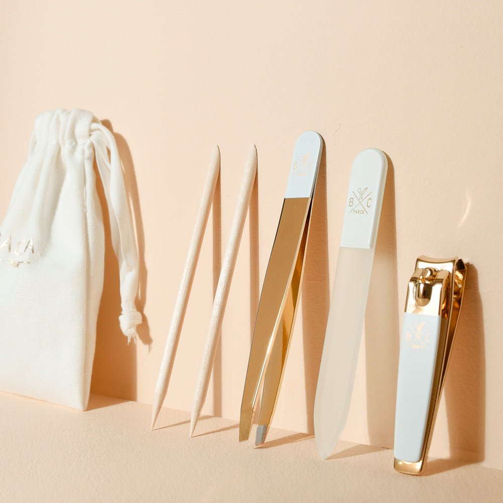 Kit manucure Bachca complet avec pochette, pince à épiler dorée, lime à ongles, coupe-ongles blanc et bâtonnets de buis, pour des ongles soignés et élégants.