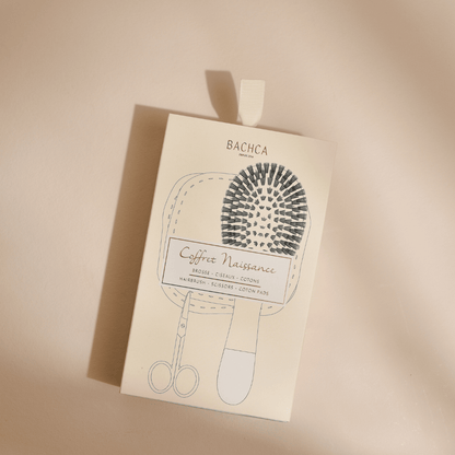 Packaging du coffret naissance de la marque Bachca posé sur un fond studio rose pâle.