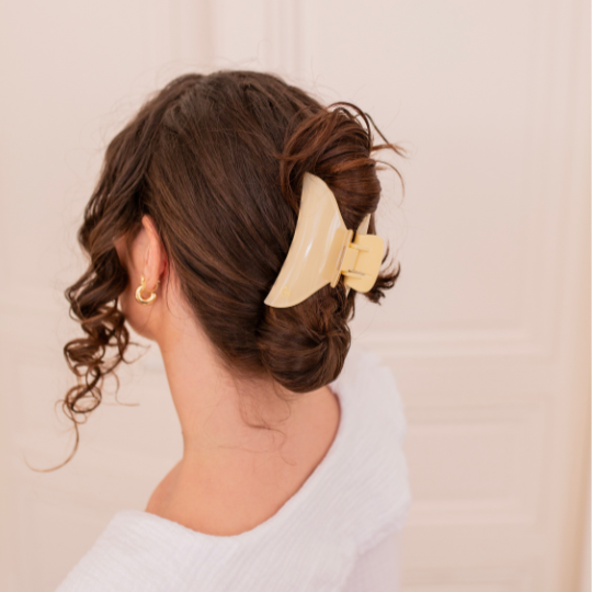 Chignon bas maintenu par une grande pince à cheveux ivoire Bachca, coiffure élégante et sophistiquée.