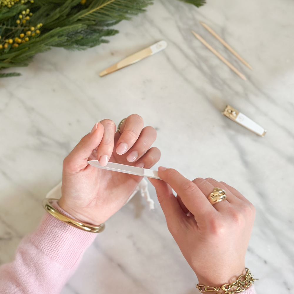 Mains de femme se limant les ongles à l'aide du kit manucure de la marque Bachca.