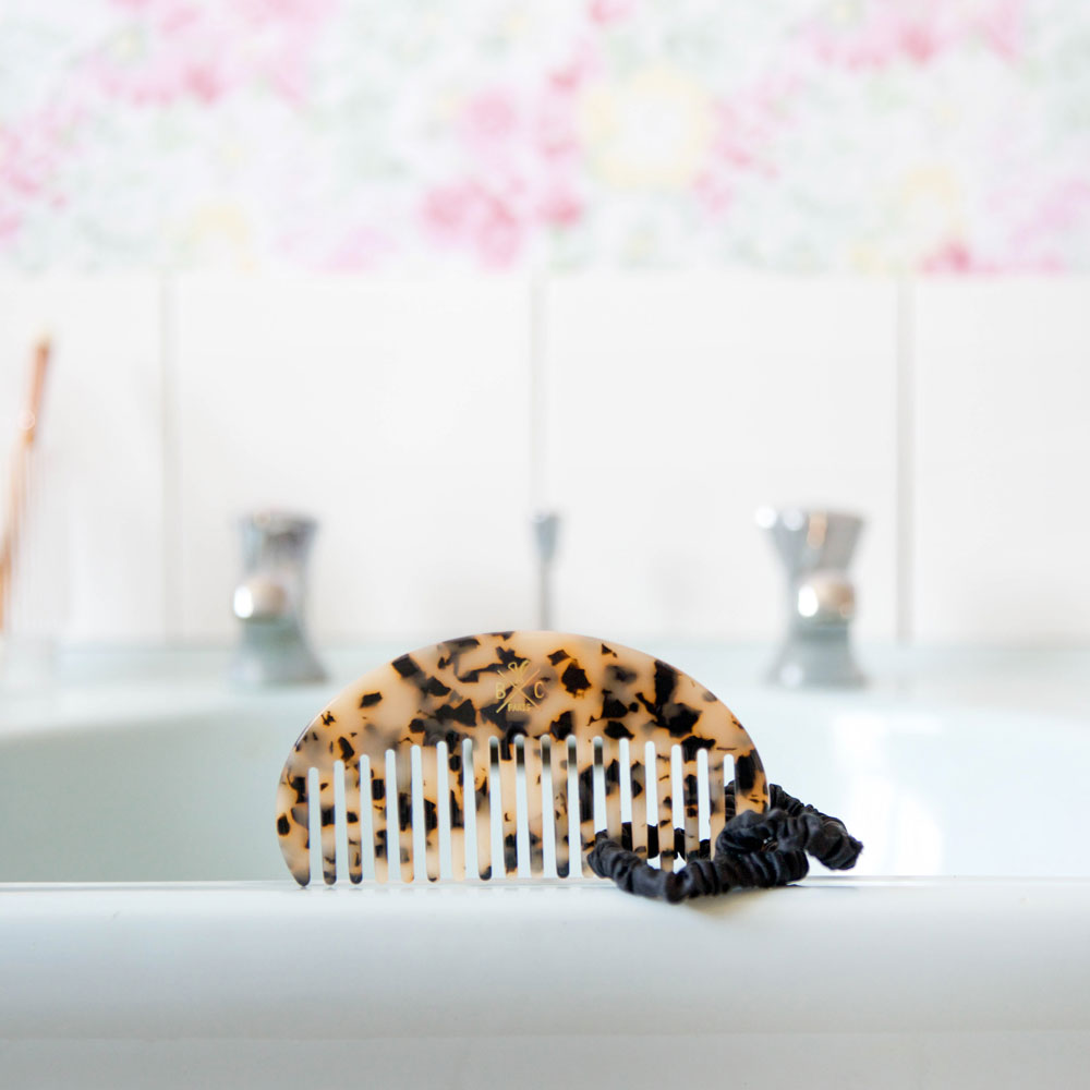 Le peigne écailles Bachca dans une salle de bain avec les chouchous en soie.
