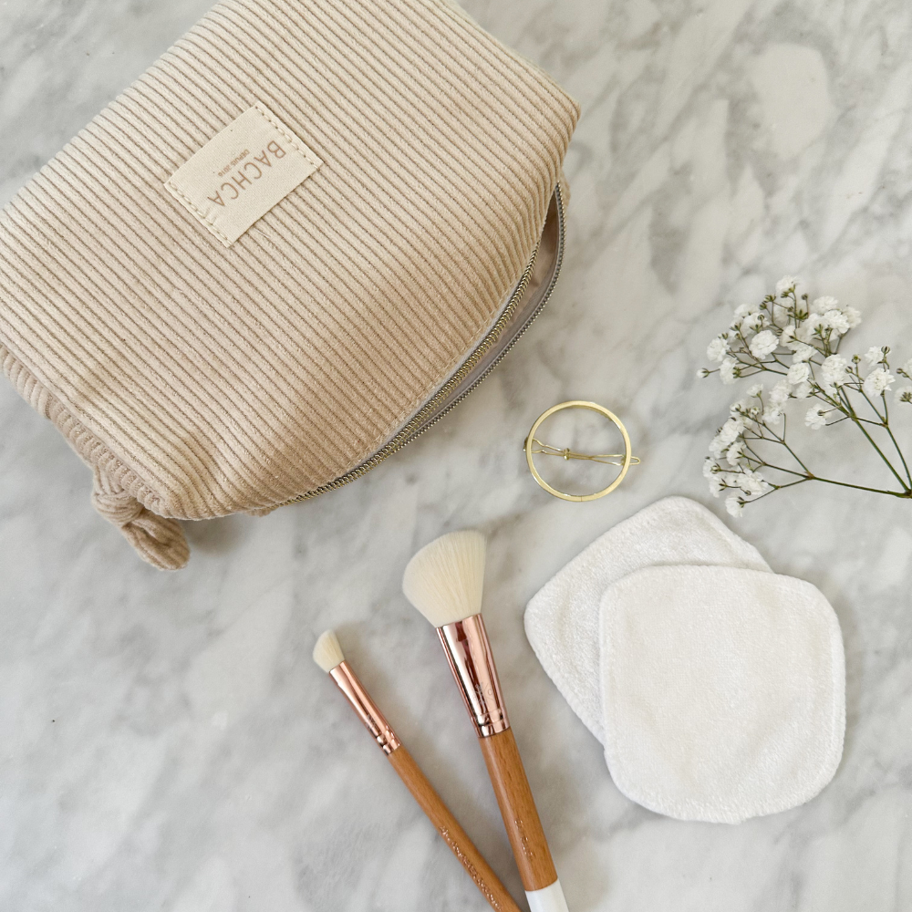 Trousse makeup Bachca en velours côtelé beige avec pinceaux, cotons lavables et barrette dorée.