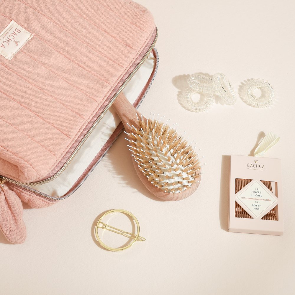 Trousse mix and match Bachca : brosse en bois, trousse rose, élastiques transparents, pinces guiches et barrette ronde dorée.