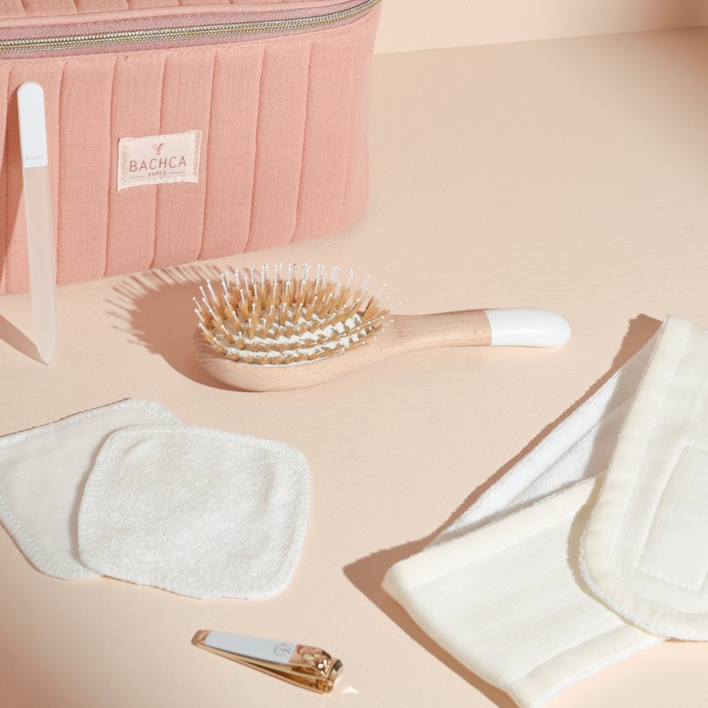 Vanity all in one Bachca rose avec brosse en bois, bandeau maquillage et soin, cotons réutilisables, lime à ongles et coupe-ongles dorés.
